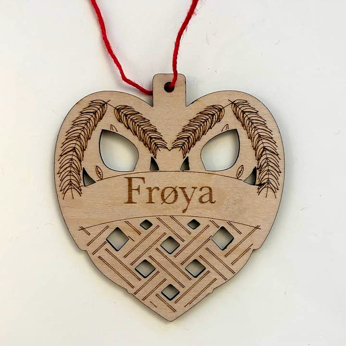 Woven heart Christmas ornament in laser-cut birch wood, engraved with the sample name Frøya, hanging from a red cord