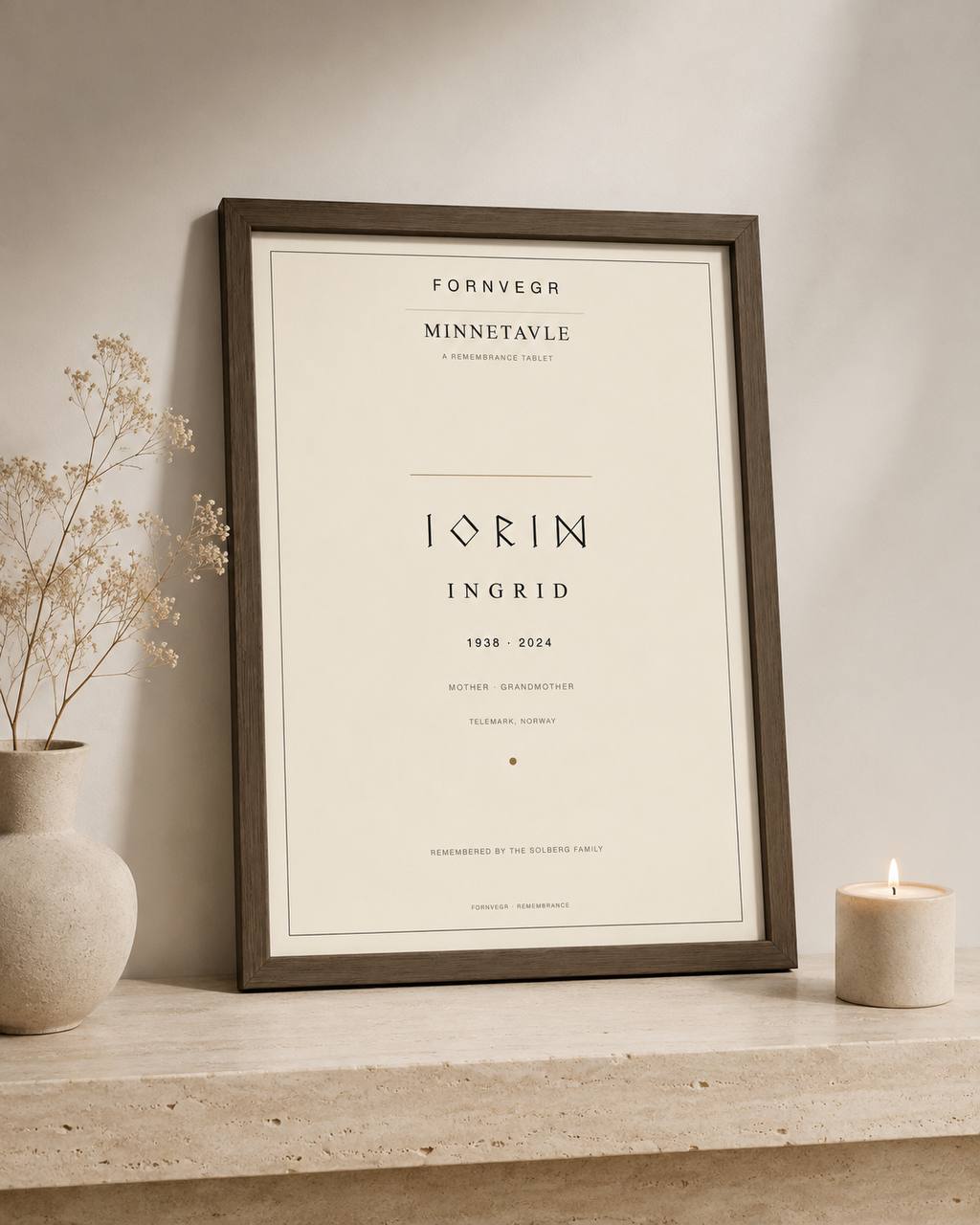Minnetavle personalized memorial print in a dark wood frame on a stone console